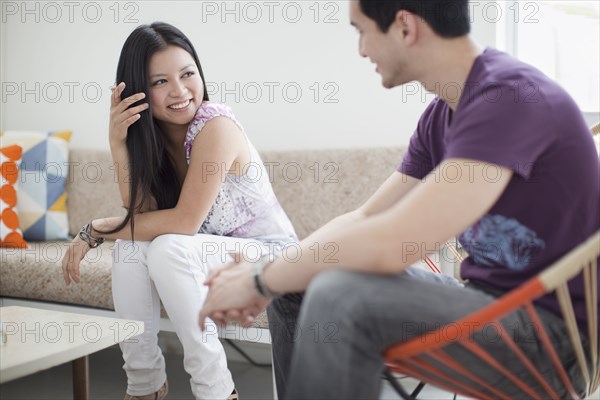 Smiling woman talking to husband in living room