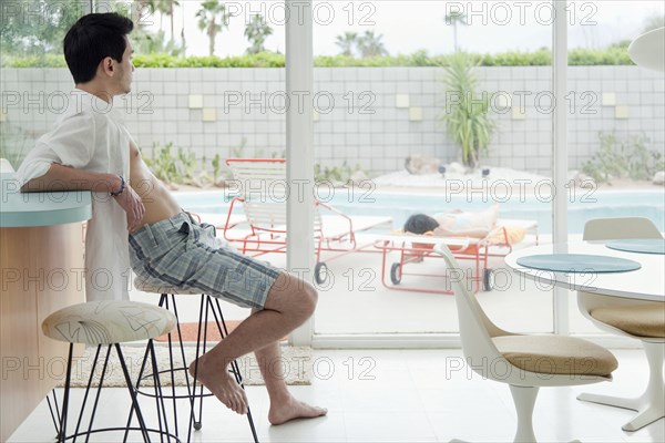 Mixed race man sitting on bar stool