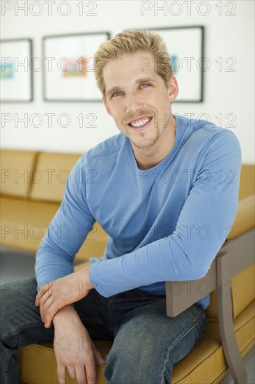 Smiling Caucasian man sitting on sofa