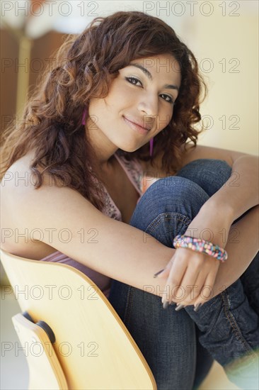 Smiling Hispanic woman sitting in chair