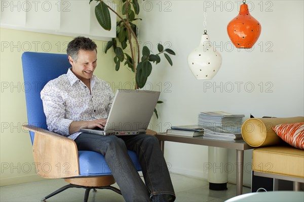 Man typing on laptop in living room