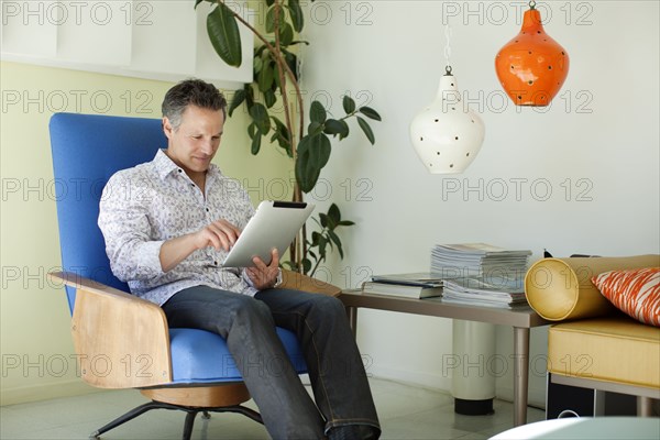 Man using digital tablet in living room