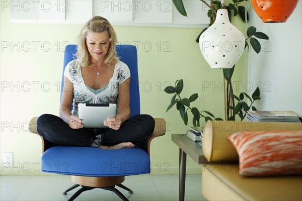 Caucasian woman using digital tablet in living room