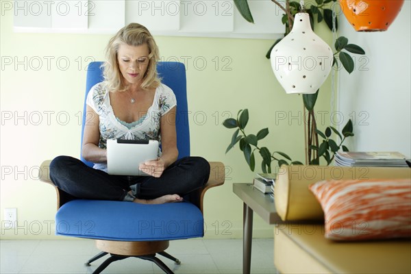 Caucasian woman using digital tablet in living room