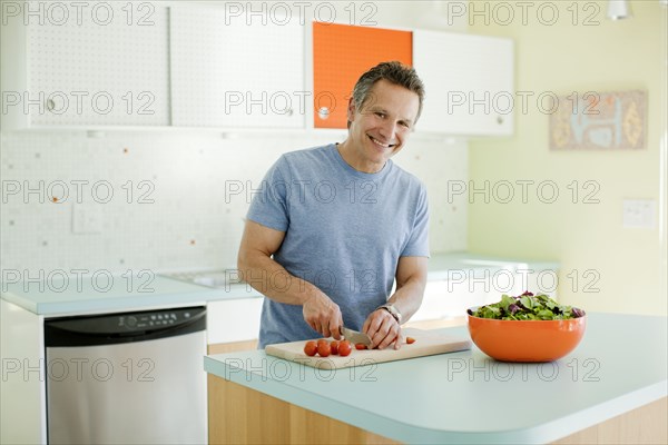 Man cutting vegetables in kitchen
