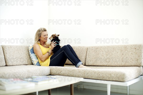 Caucasian woman relaxing on sofa with dog