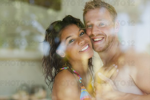 Couple hugging behind window