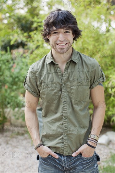 Smiling mixed race man with hands in pockets