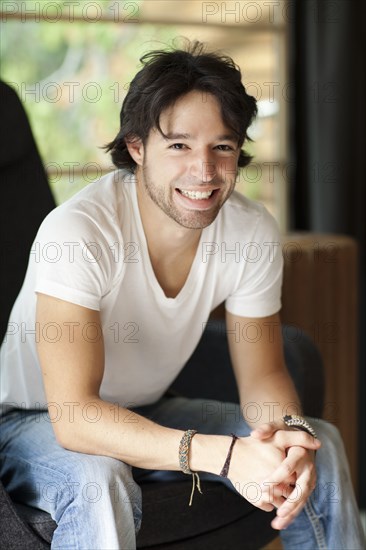 Smiling mixed race man with hands clasped