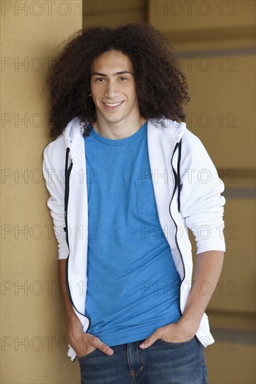 Mixed race teenager standing with hands in pockets