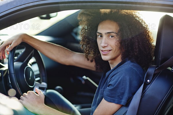 Mixed race teenager sitting in car