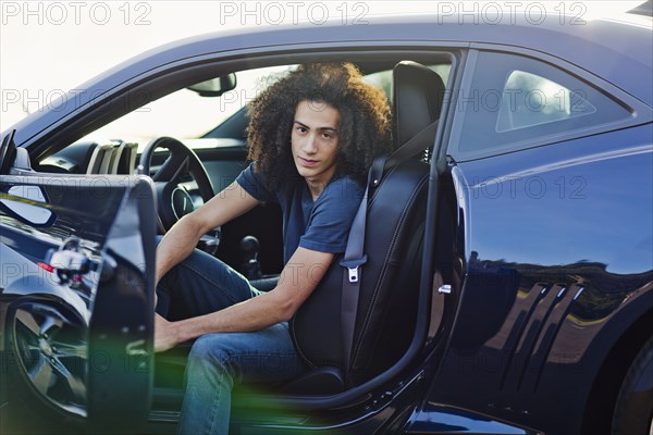 Mixed race teenager sitting in car