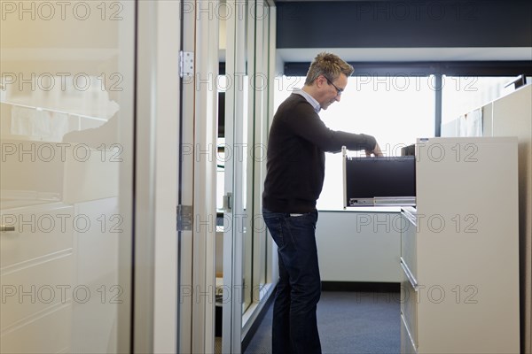 Caucasian businessman opening office cabinet