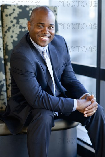 Smiling African American businessman sitting in office lobby