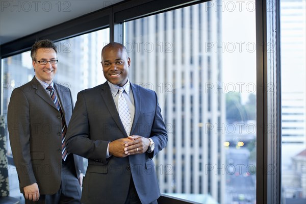 Smiling businessmen standing in office
