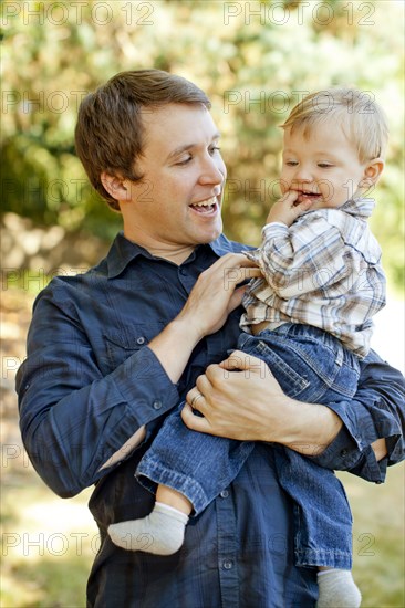 Caucasian father holding son outdoors