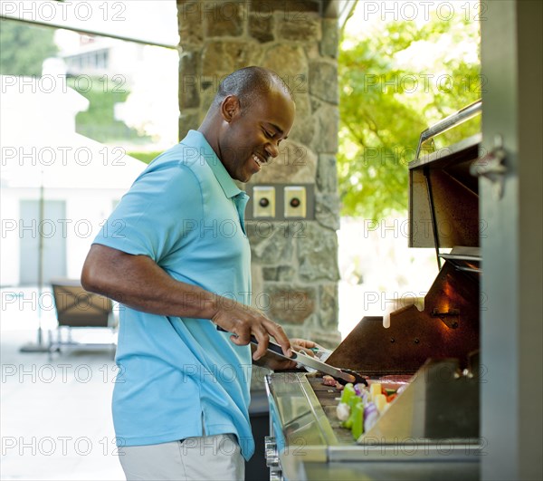 African American man grilling food on barbecue