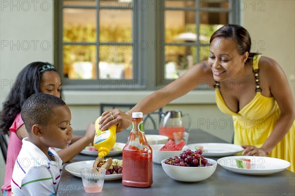 African American mother preparing lunch for children