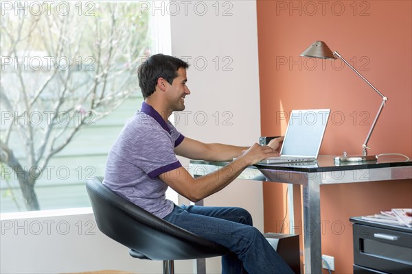 Mixed race man using laptop