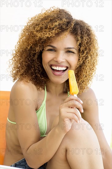 Mixed race woman eating popsicle