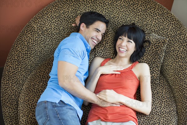 Couple laying on modern chair