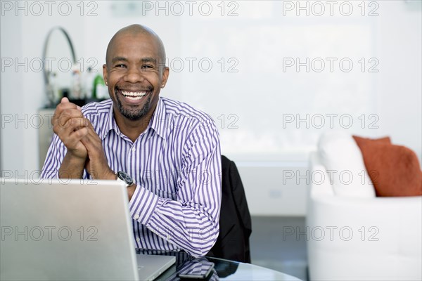Black businessman sitting with laptop