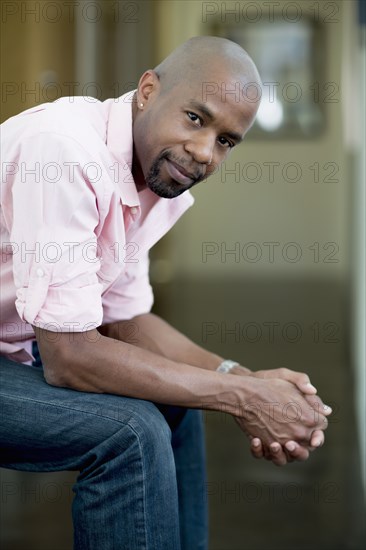 Serious Black man with hands clasped