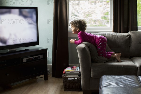 Mixed race girl watching television