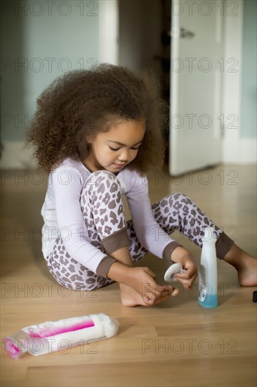 Mixed race girl using polish remover