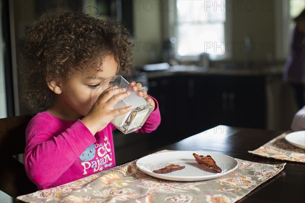 Mixed race girl drinking milk