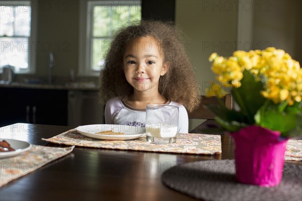 Mixed race girl eating breakfast