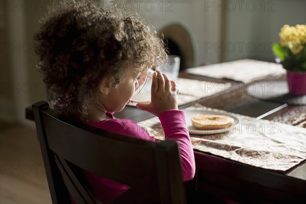 Mixed race girl eating breakfast