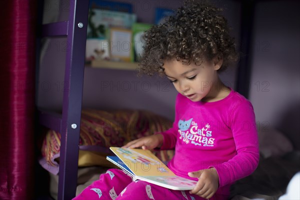 Mixed race girl reading book