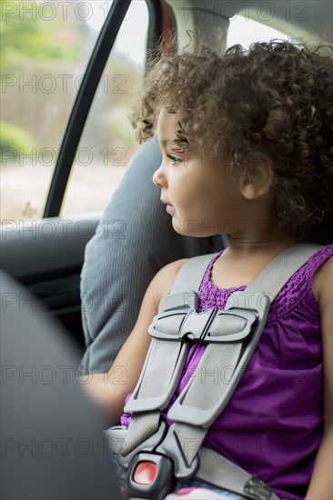 Mixed race girl sitting in car seat