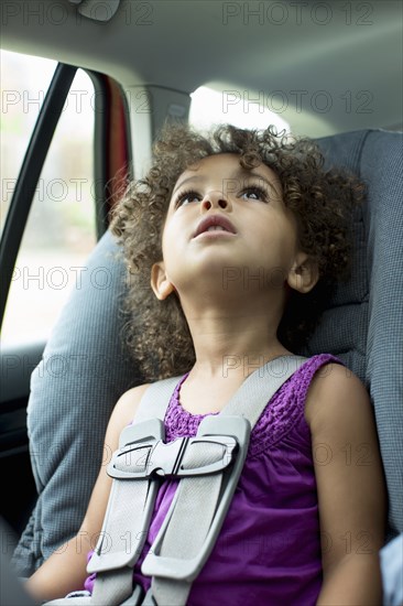 Mixed race girl sitting in car seat