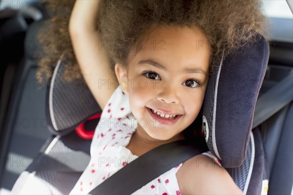 Mixed race girl sitting in car seat