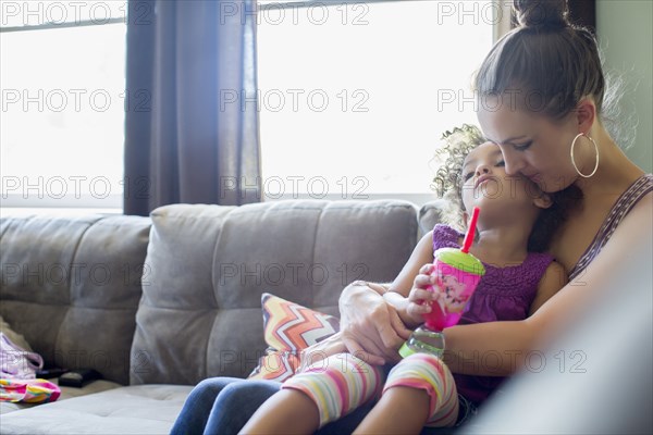 Mother holding daughter on lap