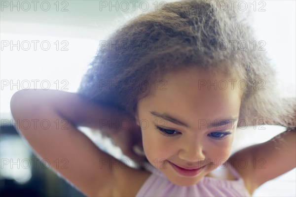 Mixed race girl tying her shirt