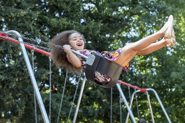 Mixed race girl swinging