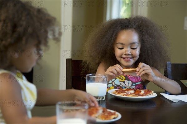 Mixed race girls eating pizza