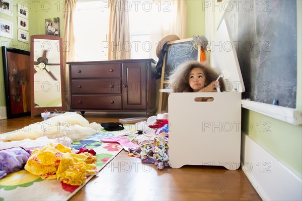 Mixed race girl hiding in hamper