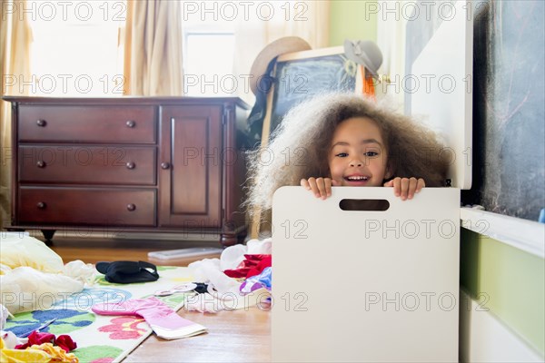 Mixed race girl hiding in hamper