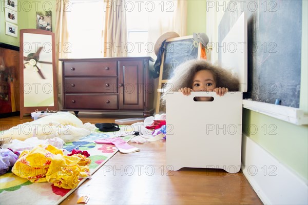 Mixed race girl hiding in hamper