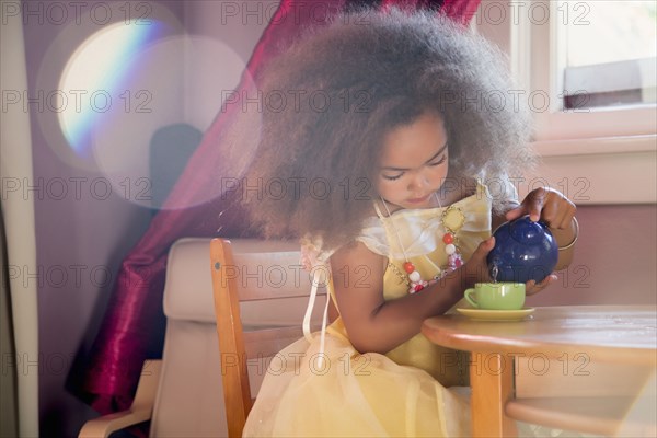 Mixed race girl pouring tea