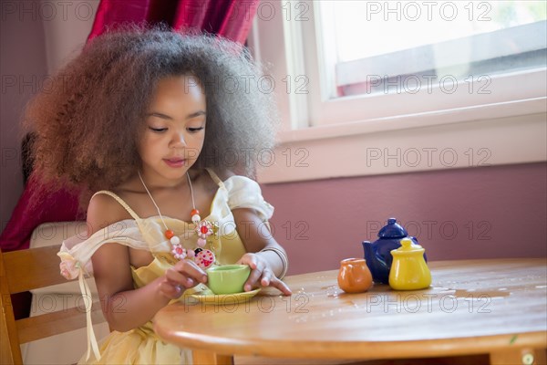 Mixed race girl having tea party