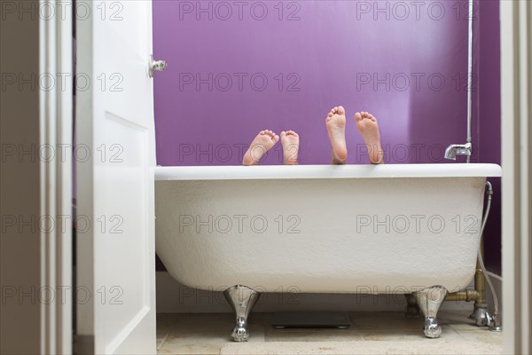 Mixed race girls playing in bathtub