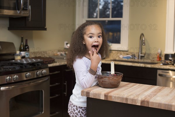 Mixed race girl licking batter