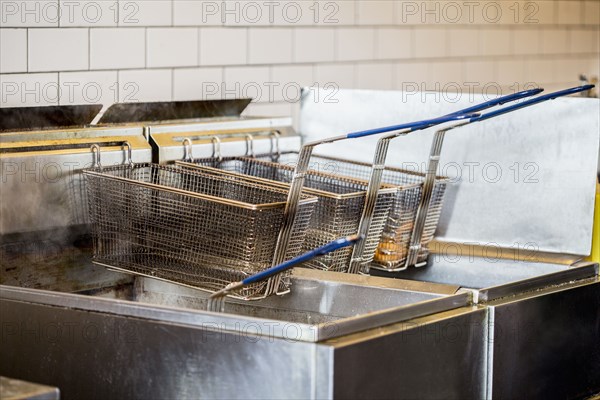 Baskets on deep fat fryer in restaurant