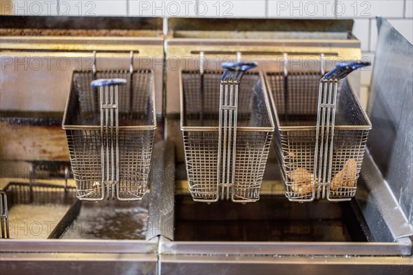 Baskets on deep fat fryer in restaurant