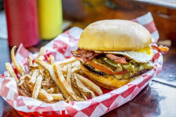 Basket of french fries with cheeseburger and egg